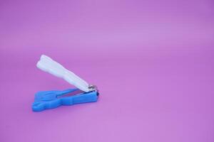 cute nail clippers isolated on purple background. cute nail clippers with blue and white color combination photo