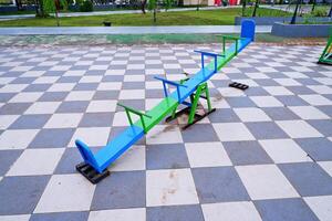 seesaw that can be played by 4 children. seesaw with a combination of blue and green colors. photo
