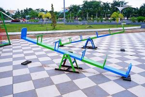 seesaw that can be played by 4 children. seesaw with a combination of blue and green colors. photo