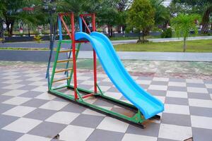 blue slide with iron stairs for children to play in the park photo
