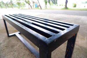 black bench made of iron. a bench with gaps in the seat photo