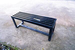 black bench made of iron. a bench with gaps in the seat photo