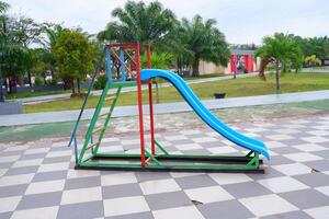 blue slide with iron stairs for children to play in the park photo