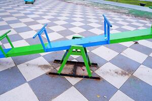 seesaw that can be played by 4 children. seesaw with a combination of blue and green colors. photo