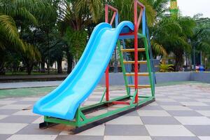 blue slide with iron stairs for children to play in the park photo