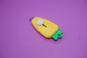 cute mini cutter with carrot shape. cute cutter isolated on purple background. photo