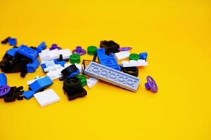 A collection of toy blocks isolated on a yellow background. Toys that are played by stacking them like stacking bricks. photo