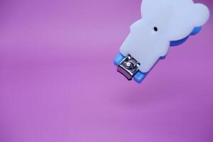 cute nail clippers isolated on purple background. cute nail clippers with blue and white color combination photo