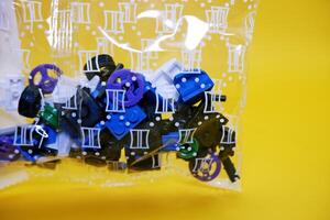 a collection of toy blocks still in plastic. a collection of toy blocks isolated on a yellow background. toys that are played by stacking them like stacking bricks. photo