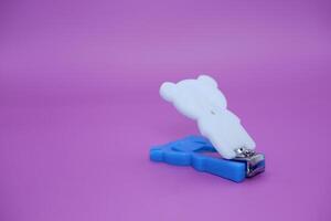 cute nail clippers isolated on purple background. cute nail clippers with blue and white color combination photo
