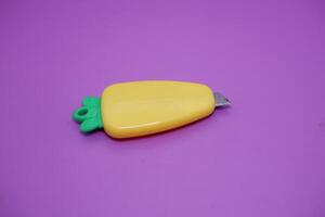cute mini cutter with carrot shape. cute cutter isolated on purple background. photo