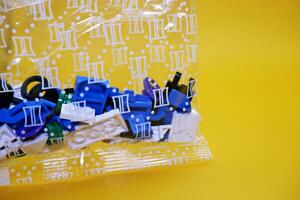 a collection of toy blocks still in plastic. a collection of toy blocks isolated on a yellow background. toys that are played by stacking them like stacking bricks. photo