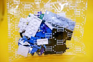 a collection of toy blocks still in plastic. a collection of toy blocks isolated on a yellow background. toys that are played by stacking them like stacking bricks. photo