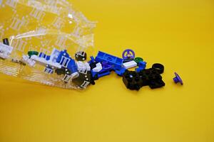 a collection of toy blocks still in plastic. a collection of toy blocks isolated on a yellow background. toys that are played by stacking them like stacking bricks. photo