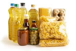 Foodstuff for donation isolated on white background with clipping path, storage and delivery. Various food, pasta, cooking oil and canned food in cardboard box. photo