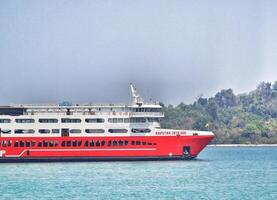 Merak, Indonesia on June 8 2023. A red ferry boat is heading towards the port of Merak. photo