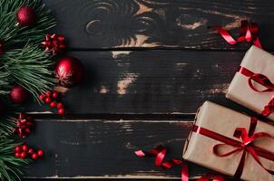 Top view photo Christmass flatlay gift boxes,red christmas tree toys and spruce brance on wooden background. Xmas backdrop with space for text.Copyspace.