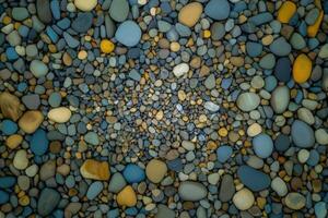 A natural surface of smooth pebbles and rough rocks creates a rugged, earthy texture photo