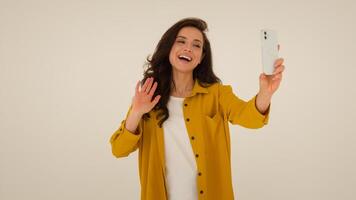 Happy Caucasian woman vlogger influencer streamer waving hand greeting smile filming blogger girl female stream broadcasting mobile phone walking show studio talk speak to subscribers blog vlog photo
