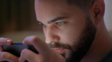 Close up Caucasian man using mobile phone smartphone cellphone gadget online play internet game stuck addict deterioration vision eyes health guy male bed bedroom network looking connection cyberspace photo