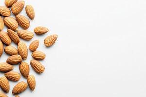A collection of raw almonds lies isolated against a bright white background, highlighting their distinct shapes and smooth textures. These nuts are popular for snacking and cooking. photo