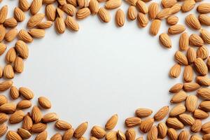 A variety of almonds are displayed in a circular arrangement on a smooth, light-colored surface, showcasing their natural texture and color. The setup emphasizes the nuts raw appeal. photo