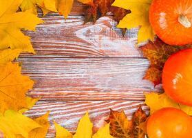 Festive autumn composition with autumn leaves and pumpkins on a wooden background. Flatlay. Top view. Copy space. Banner. photo