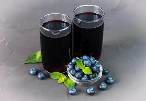 Tasty and healthy natural juice from fresh berries in a glass on a gray background. Close-up. photo