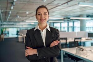 A confident businesswoman is standing and posing in a modern office environment photo