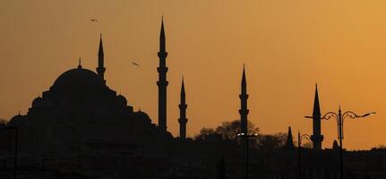 Silhouette of Sultanahmet mosque with minarets in setting sun in Istanbul Turkey. photo