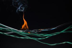 Flames from electric shocks Short-circuited cables cause sparks, explosions, excessive power usage, damaged and non-standard equipment. on a dark black background photo