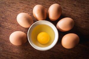 Yolk eggs for cooking in new recipe on tray at wooden background photo