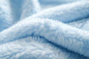 Soft blue blanket draped in gentle folds on a cozy surface at home photo