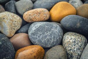 Various smooth river rocks in earthy tones arranged closely on a natural surface photo