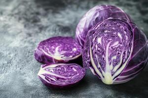 Freshly sliced purple cabbage on a textured gray surface showcasing vibrant colors and intricate patterns of the vegetable photo