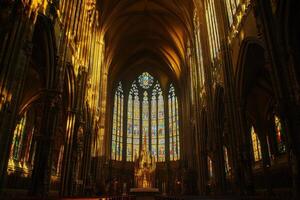 Golden light streaming through the ornate stained glass windows of a historic cathedral during the late afternoon hours photo