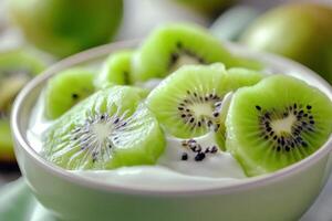 Fresh kiwi slices served on creamy yogurt in a bowl surrounded by vibrant green fruits photo