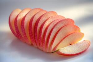 Freshly sliced red apples arranged neatly on a light surface, highlighting their vibrant colors and textures during daylight photo