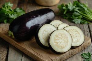Freshly sliced eggplant on a wooden cutting board with herbs in a rustic kitchen setting photo