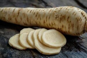 Freshly sliced parsnip on rustic wooden background emphasizing its texture and natural color photo