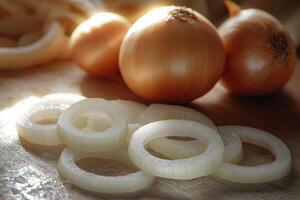 Freshly sliced onions on a wooden cutting board with whole onions in the background during early morning light photo