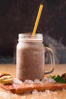 Fig Smoothie with Mint and Honey served in jar isolated on wooden board closeup side view of healthy drink photo