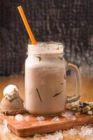 Chocolate Peanut Butter Milkshake with Ice Cream, nuts and chocolate chip served in jar isolated on wooden board side view of milkshake photo