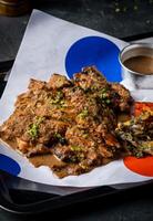Spicy Grilled Jerk Chicken Slice with Sweet and Sour Sauce and tomato served in tray isolated on grey background closeup side view of A la carte Food platter photo