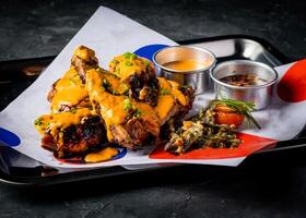Grilled Peri Peri Chicken with Creamy Sauce and Crispy Garnish green onion served in tray isolated on grey background closeup side view of A la carte Food platter photo