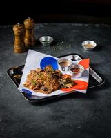 Spicy Grilled Jerk Chicken Slice with Sweet and Sour Sauce, sesame seeds and tomato served in tray isolated on grey background side view of A la carte Food platter photo
