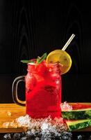 WATERMELON MOJITO Lemonade with Mint and Lime served in jar with straw isolated on wooden board side view of perfect drink for a hot summer day photo