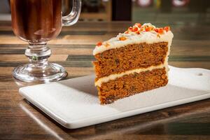 Moist Carrot Cake with Cream Cheese Frosting with Hot Chocolate Coffee mug served in tray dish isolated on table side view of cafe baked dessert food photo