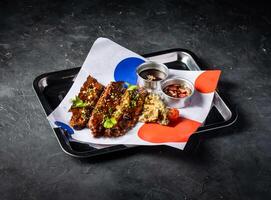 Hickory Bbq Beef Brisket Belly with Dipping Sauces, sesame seeds and green onion served in tray isolated on grey background side view of A la carte Food platter photo