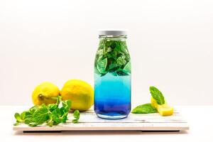 Refreshing Blue Lagoon Lemonade with Mint and Lemon served in bottle isolated on wooden board side view of cold beverage on white background photo